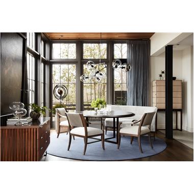 Room Scene: HC7243-10/HC7244-10 Pivot Dining Table shown in standard Truffle finish with Browned Steel base, HC7205-23 Saber Leg Dining Chair shown in  standard Truffle finish and in HC327 leather on back and arms and seat in HC4302-16 fabric, HC7207-72 Betty Banquette shown in standard Truffle finish and in HC251-60 fabric, 7267-10 Russell Cabinet shown in optional Dark Walnut finish with Bronze hardware and in HC9004-92 leather with NS-05 Natural Nails and HC7289-70 Plaited Chest shown in optional Dark Walnut finish with standard Blackened Steel base.